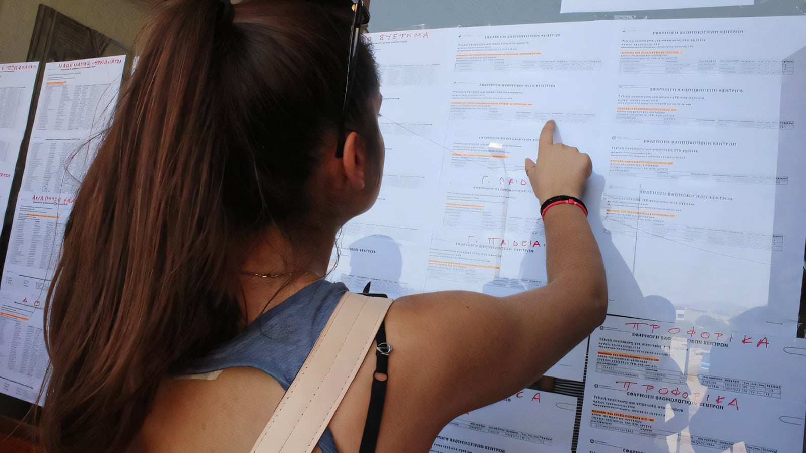 Μαθητές κοιτούν τα αποτελέσματα των εξετάσεων